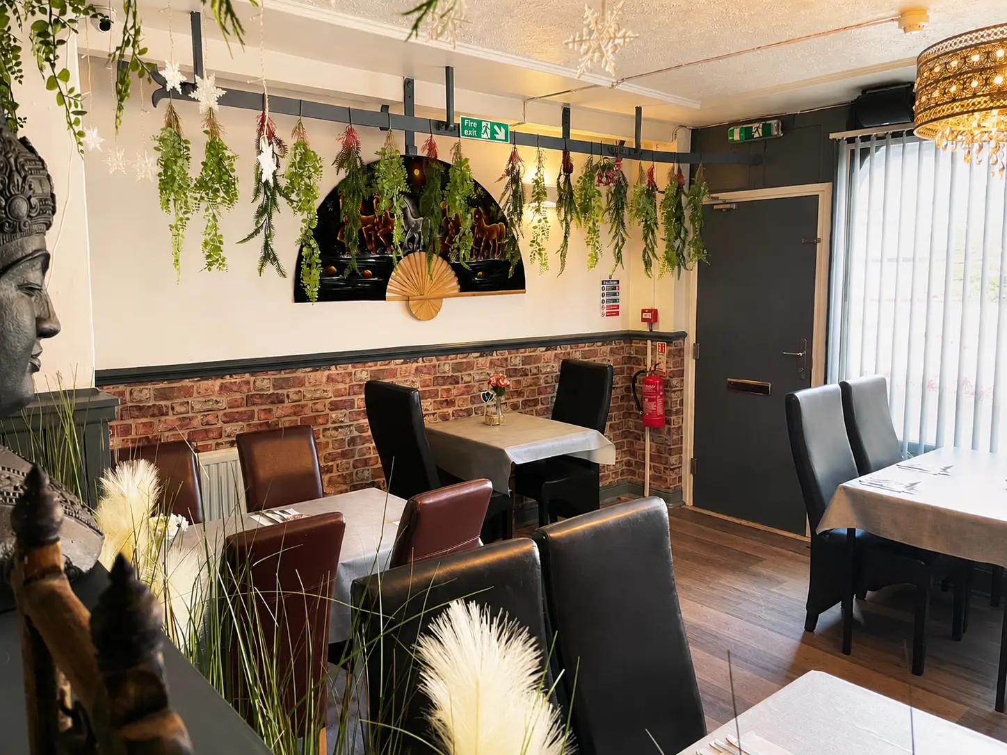 Warm dining area with hanging plants at Tawan Chay