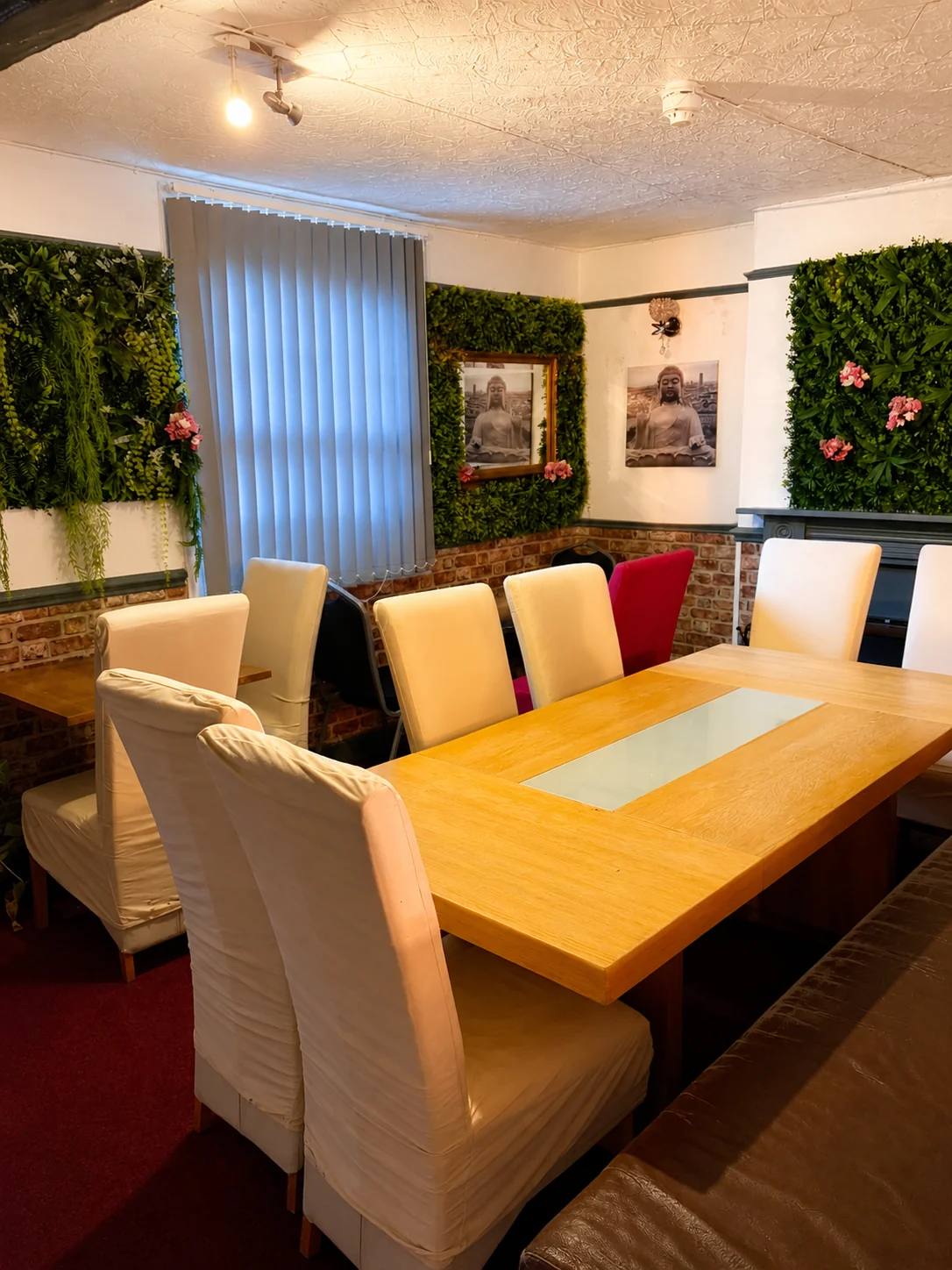 Dining seating area with green wall decor at Tawan Chay